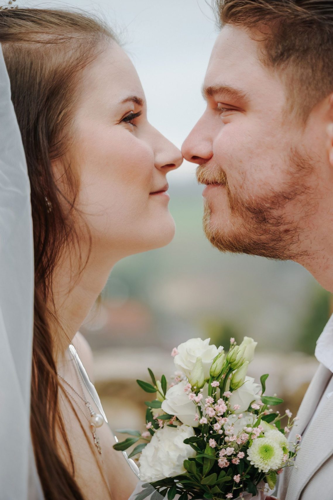 Ein Blick voller Liebe Brautpaar schaut sich liebevoll in die Augen, umgeben von Blumen und natürlicher Umgebung.